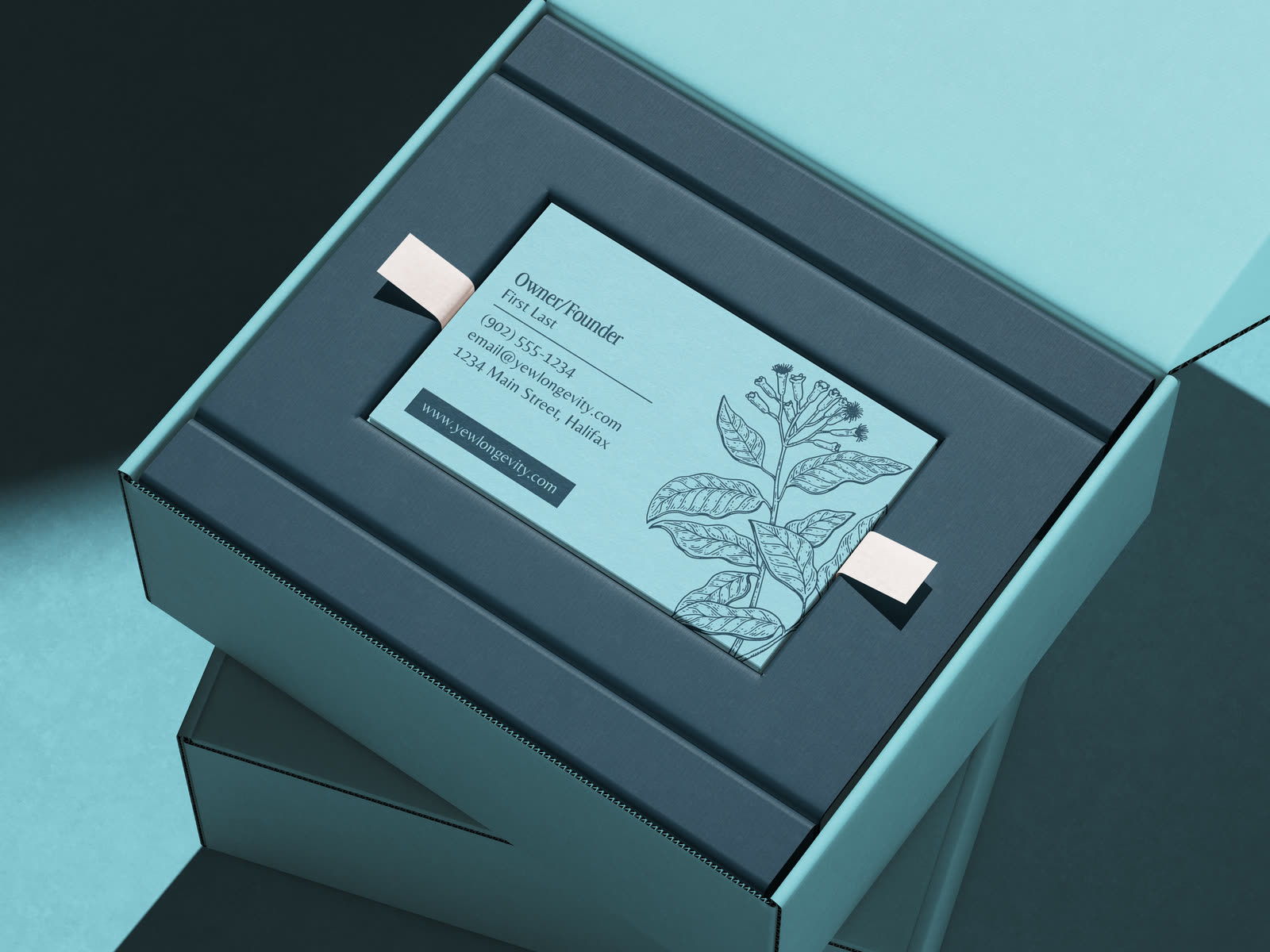 YEW mailer boxes stacked, the business card set into the lid
