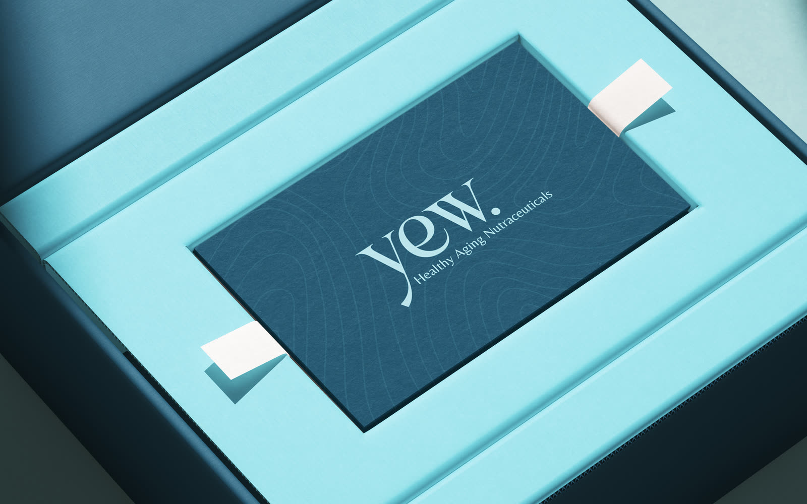 The YEW mailer box open, brand card seated in the lid